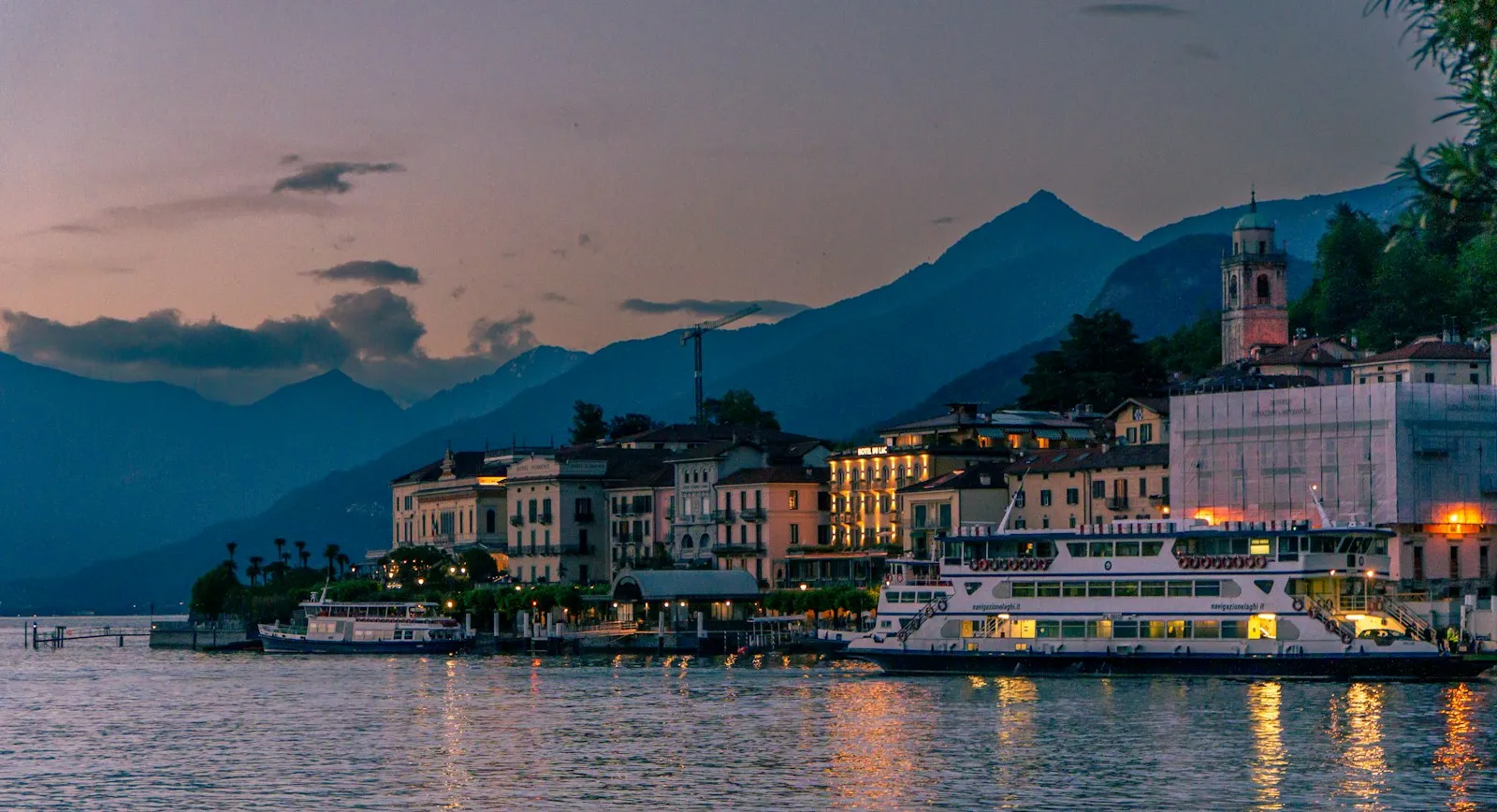 Traghetto attraccato a Bellagio con le montagne al tramonto