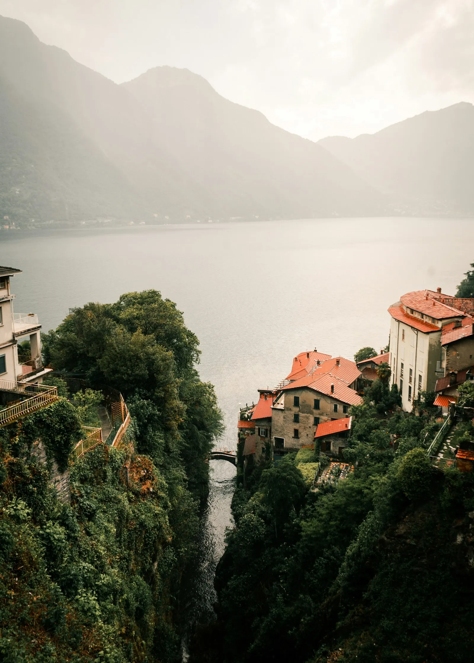 Borgo di pietra arroccato su una scogliera verde sopra il lago