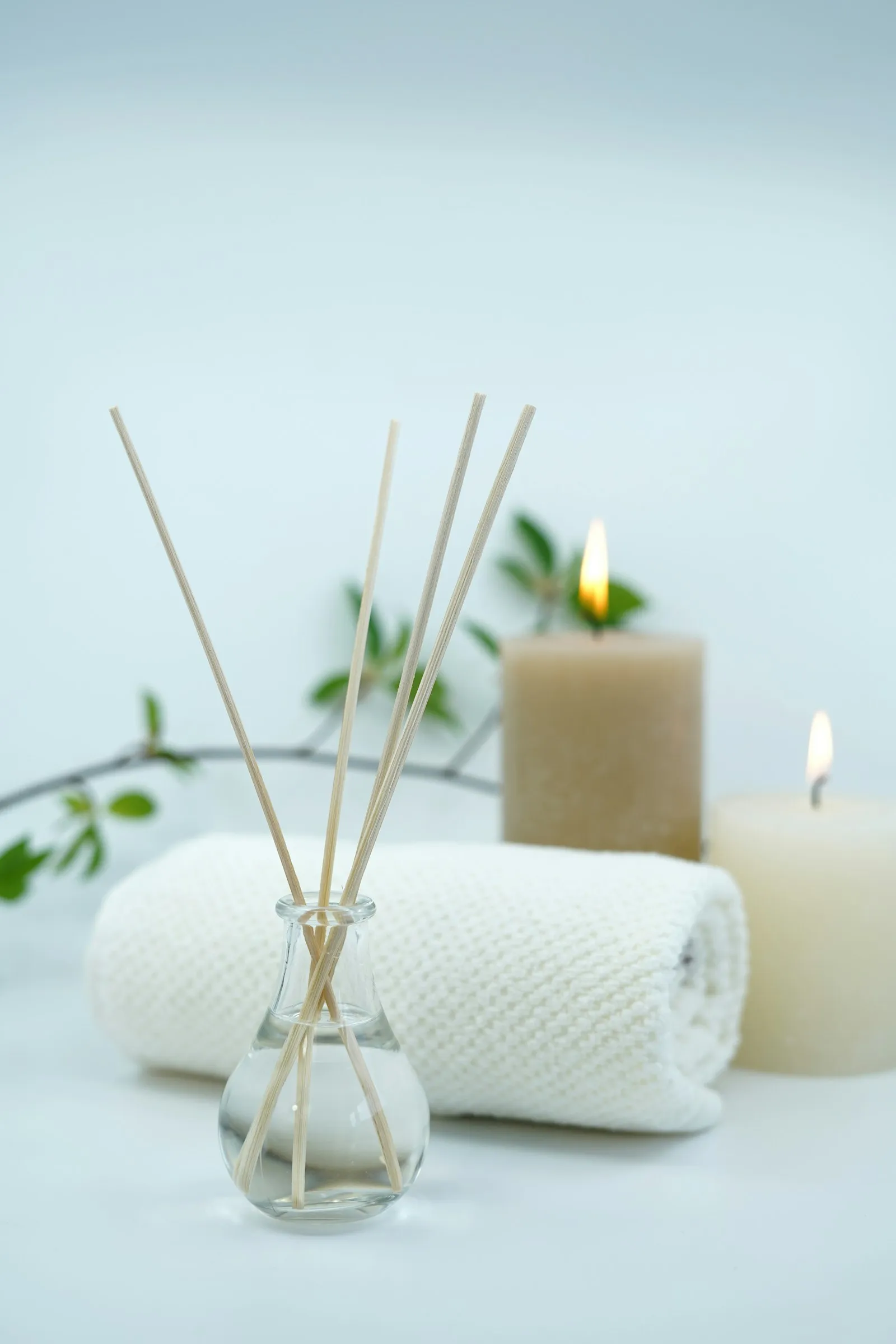 Diffusore con bastoncini, asciugamano arrotolato e candele