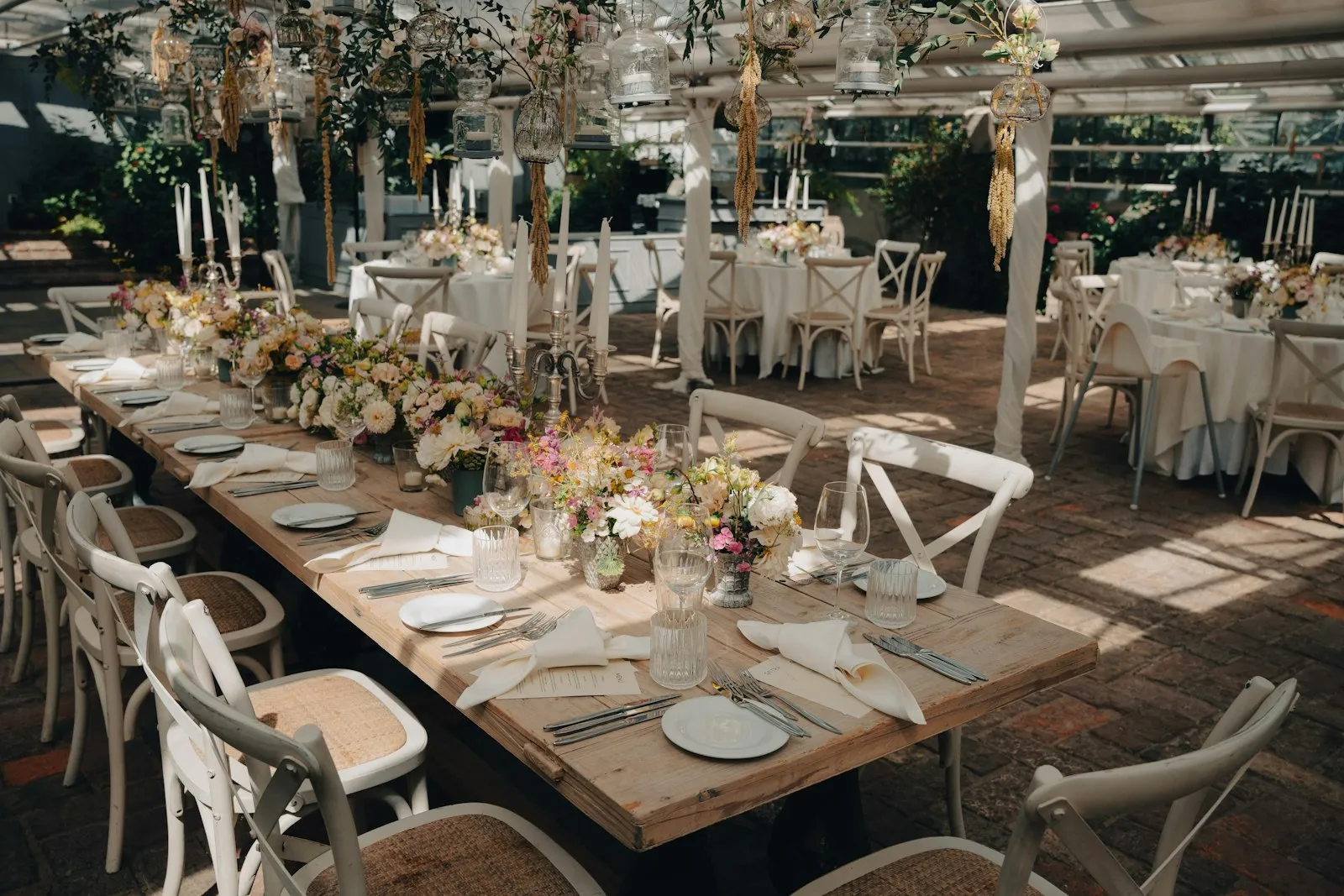 Lunga tavolata apparecchiata per un matrimonio con fiori bianchi