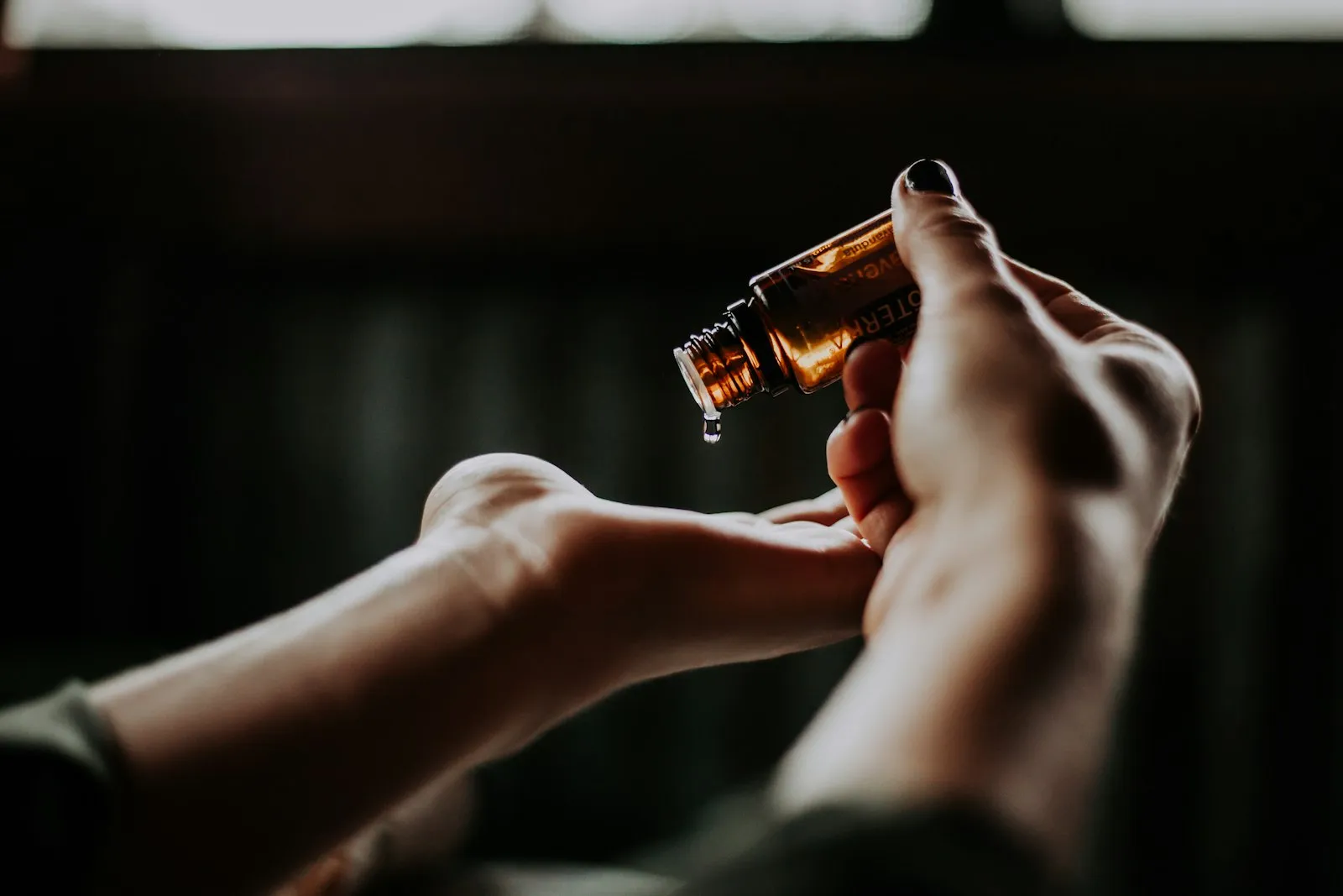 Mano che tiene un flacone di olio essenziale