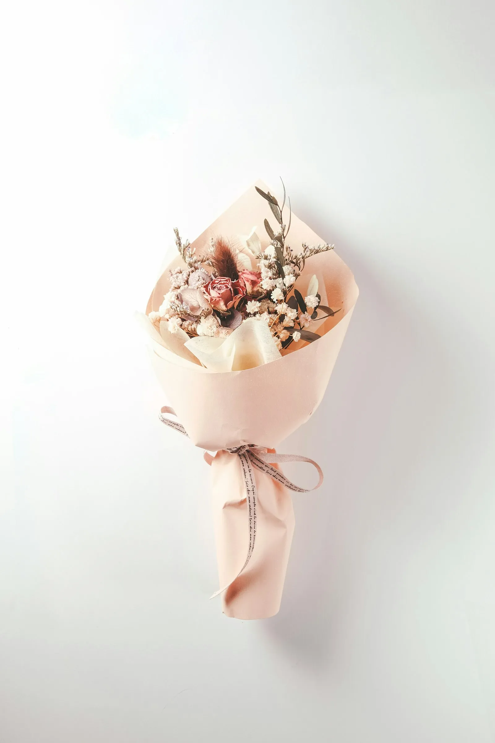 Bouquet di fiori secchi avvolto in carta pesca con fiocco
