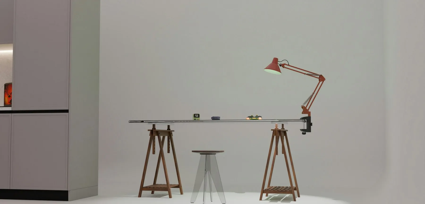 Tavolo da disegno con sgabello e lampada rossa in uno studio bianco
